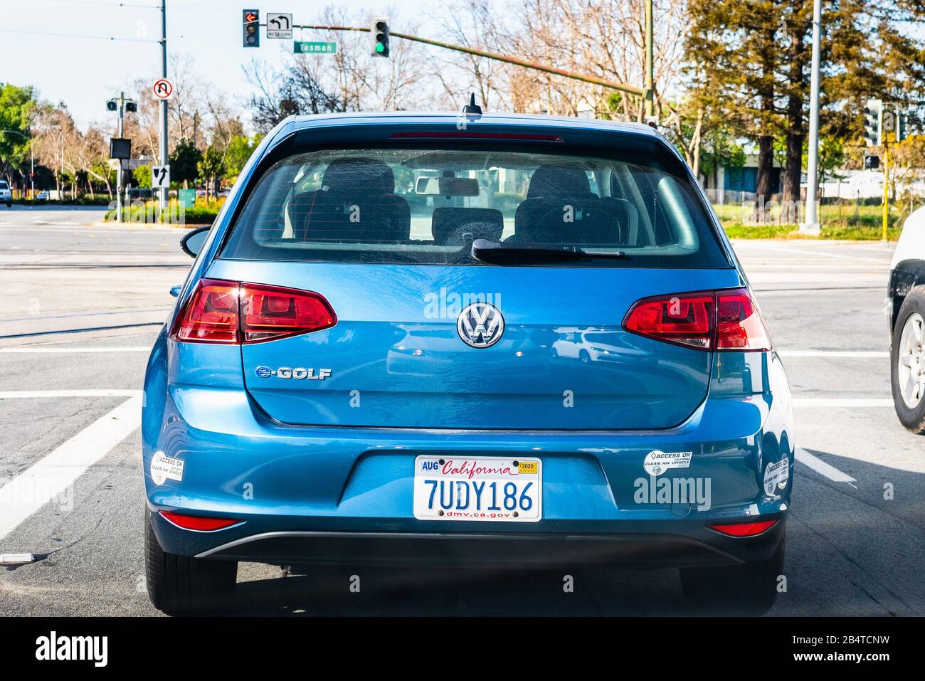 Feb 27, 2020 San Jose / CA / USA - Back view of blue Volkswagen e-Golf driving on a busy city street; VW e-Golf is the electric version of the regular Stock Photo