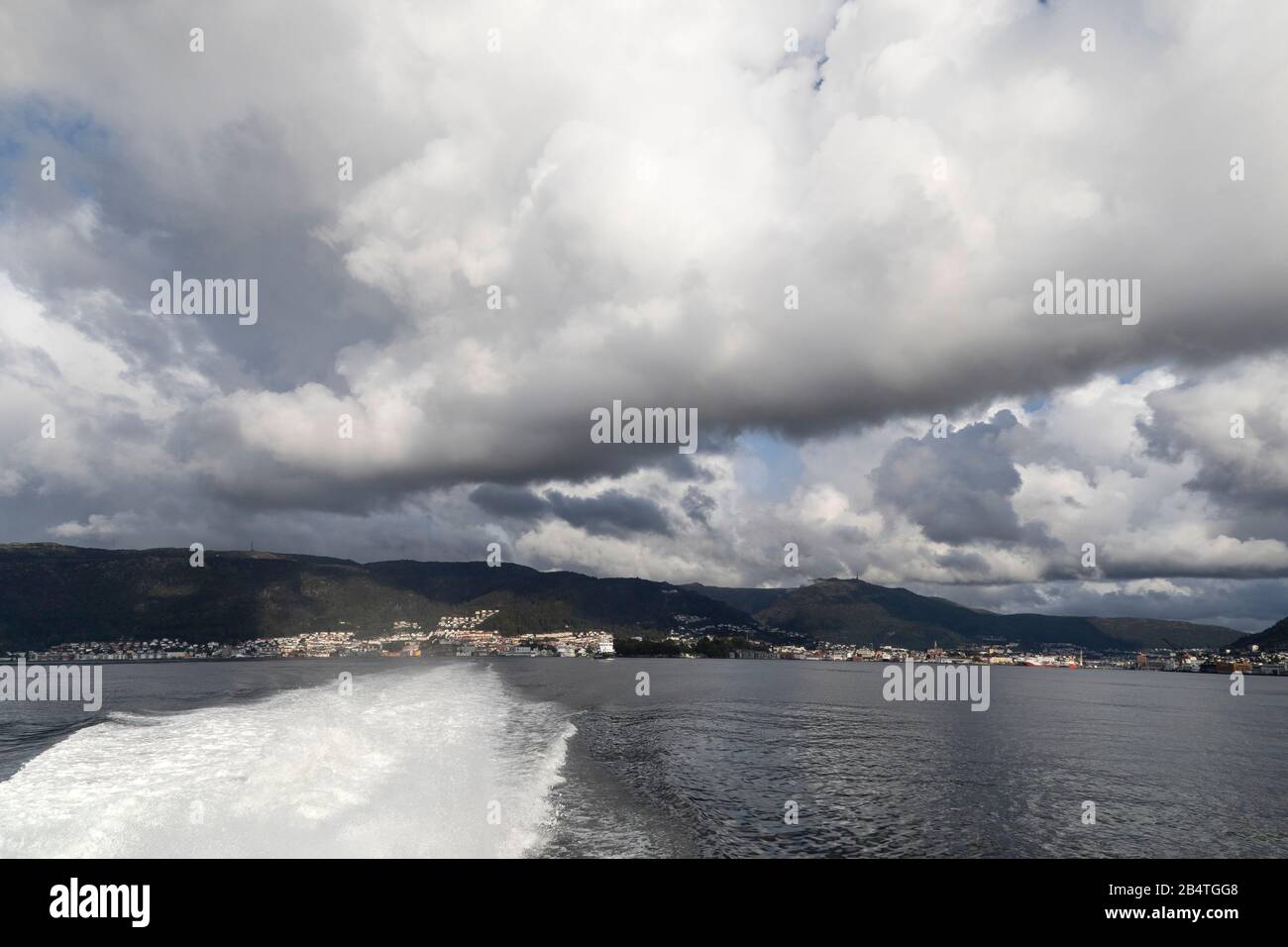 Heavy clouds over Byfjorden and city of Bergen, Norway. View from a high speed passenger vessel. Stock Photo