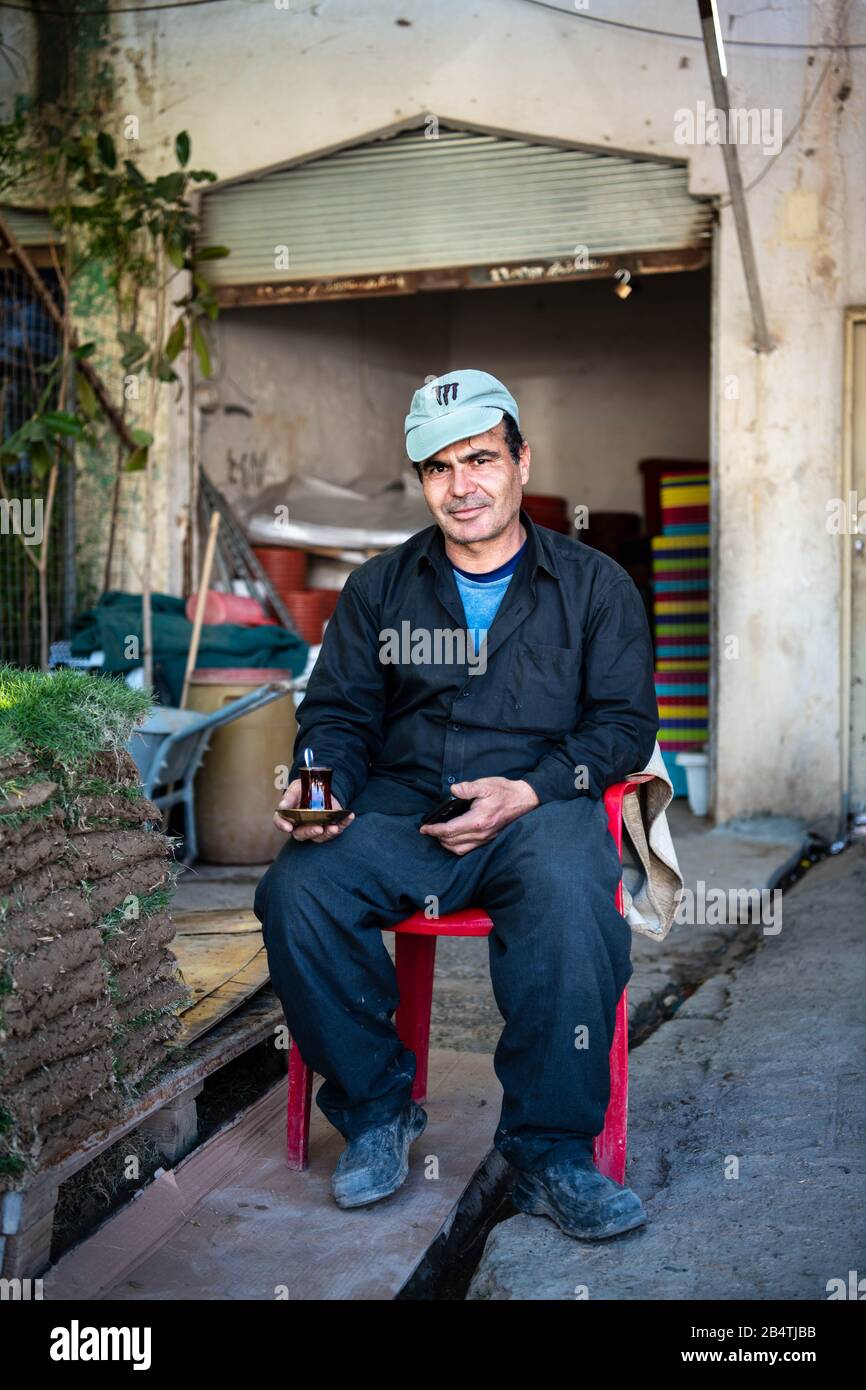Iraq, Iraqi Kurdistan, Arbil, Erbil. The boss of a flower shop in Etbil is posing with a cup of