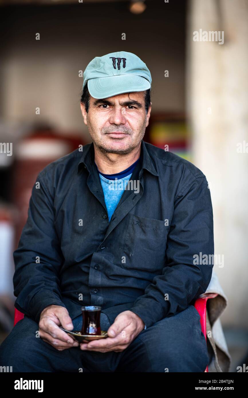 Iraq, Iraqi Kurdistan, Arbil, Erbil. The boss of a flower shop in Etbil is posing with a cup of