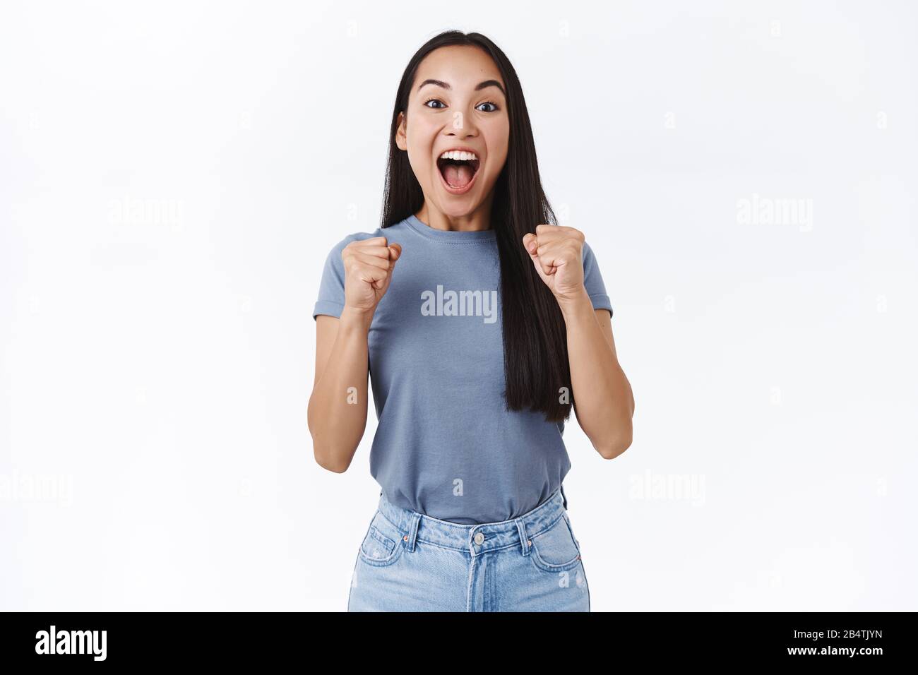 Relieved, happy emotional good-looking asian woman feeling sweet success, scream from happiness and joy, clench fists jumping as triumphing, yelling Stock Photo