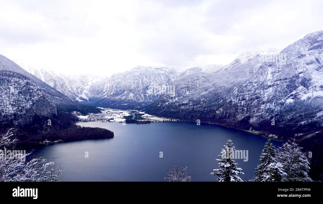 Viewpoint of Hallstatt Winter snow mountain landscape hike epic mountains outdoor adventure and lake through the pine forest in upland valley leads to Stock Photo