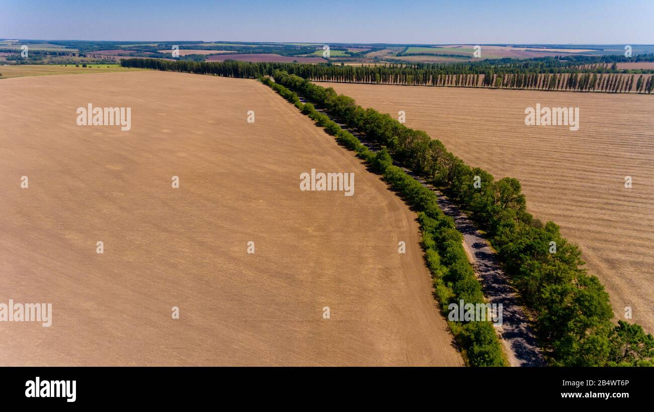 Aerial view of asphalt road passes through the field Stock Photo - Alamy