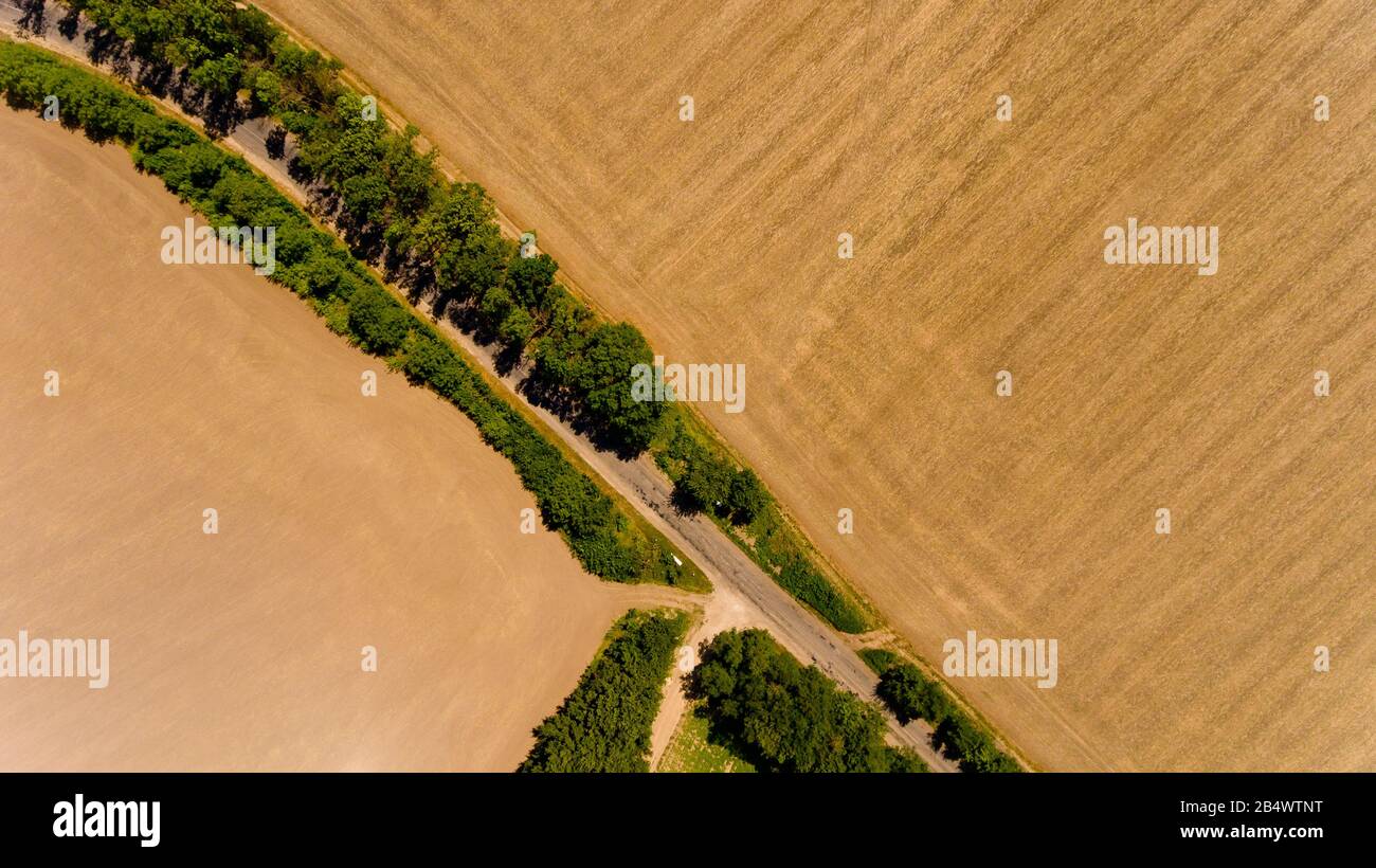 Aerial view of asphalt road passes through the field Stock Photo - Alamy