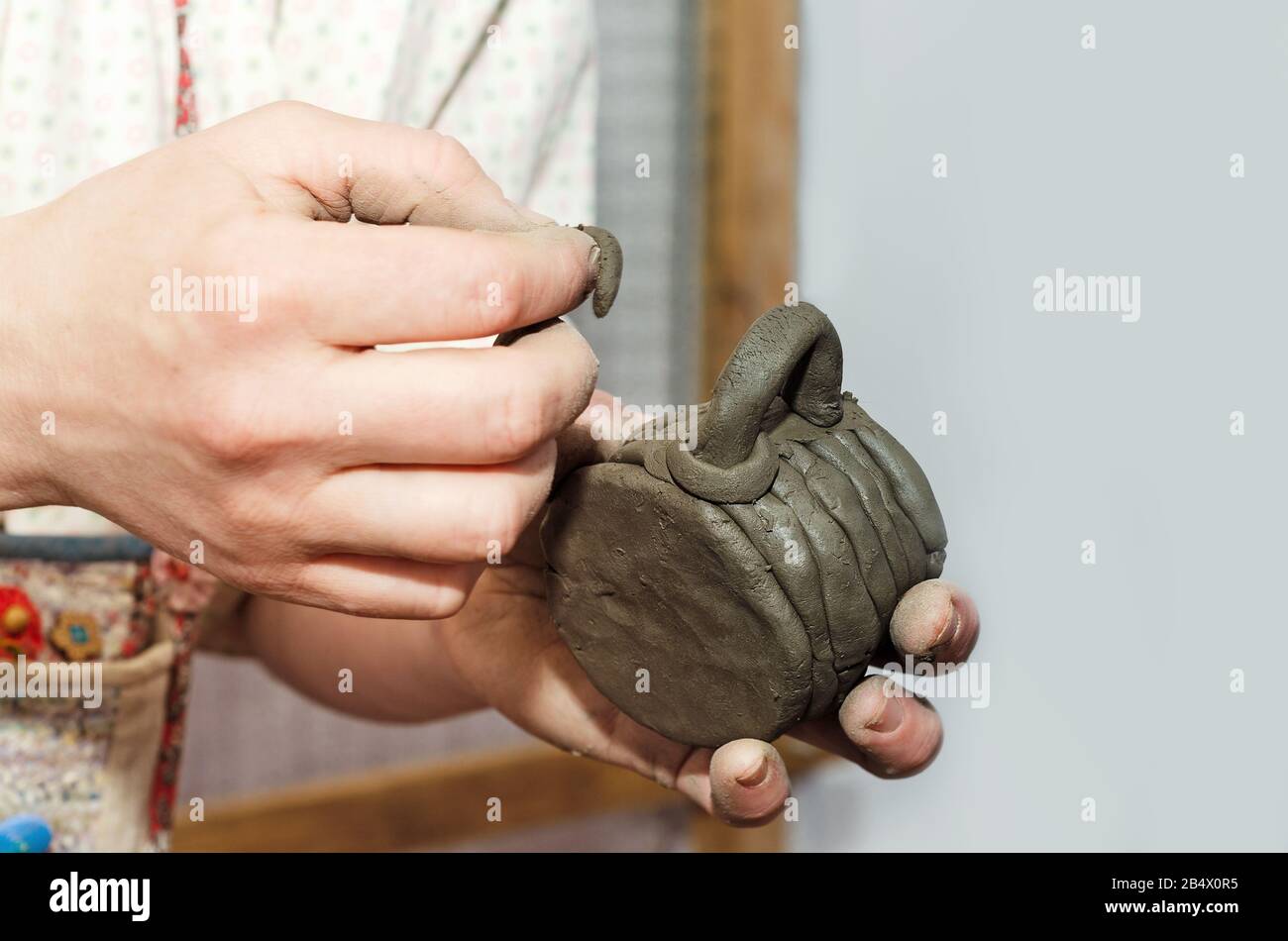 A woman 's hand makes a blank for a clay mug, hand -sculpting ceramics. Lesson for children at the Maslenitsa fair Stock Photo