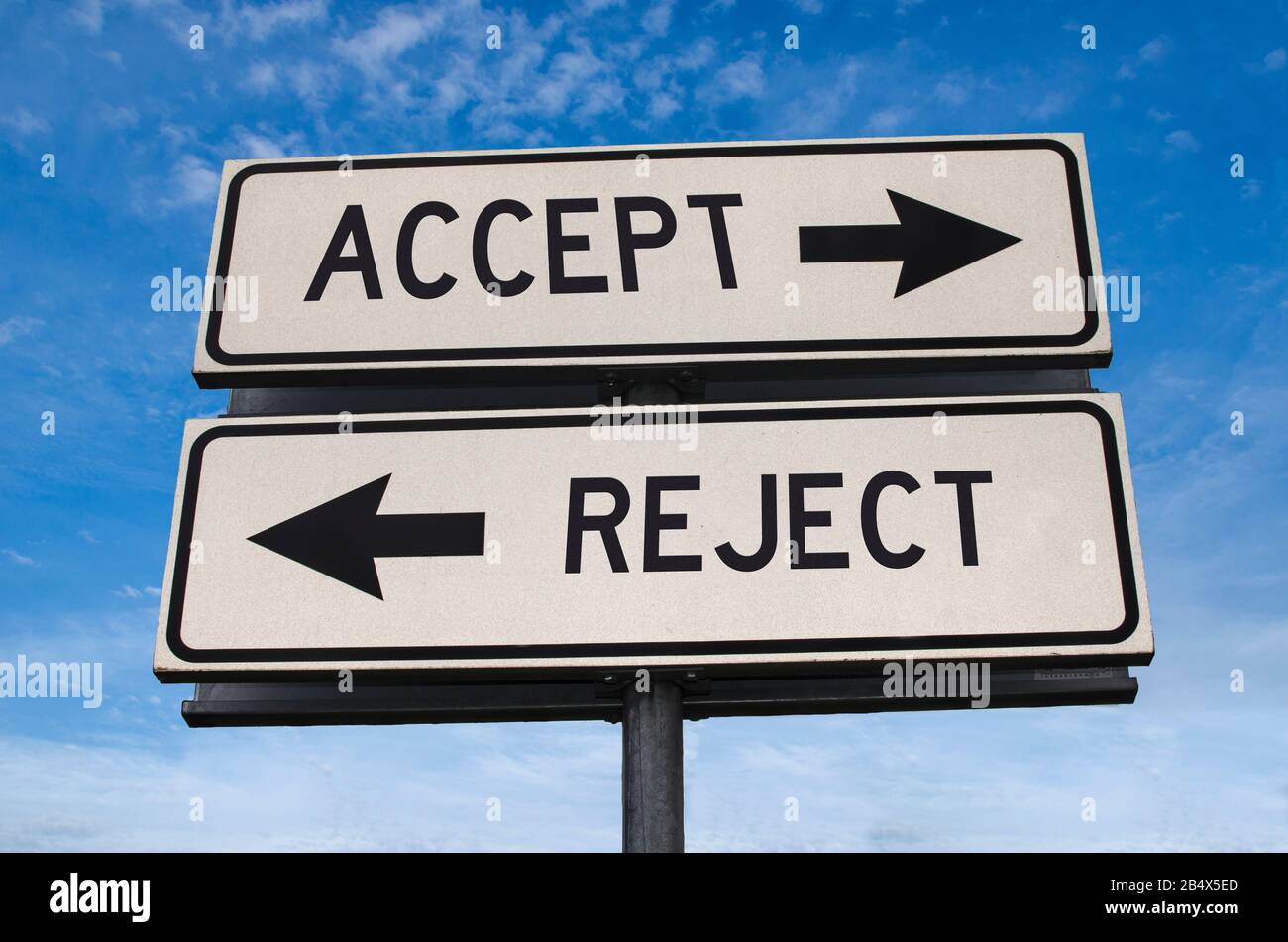 Accept vs reject. White two street signs with arrow on metal pole with word. Directional road. Crossroads Road Sign, Two Arrow. Blue sky background. Stock Photo