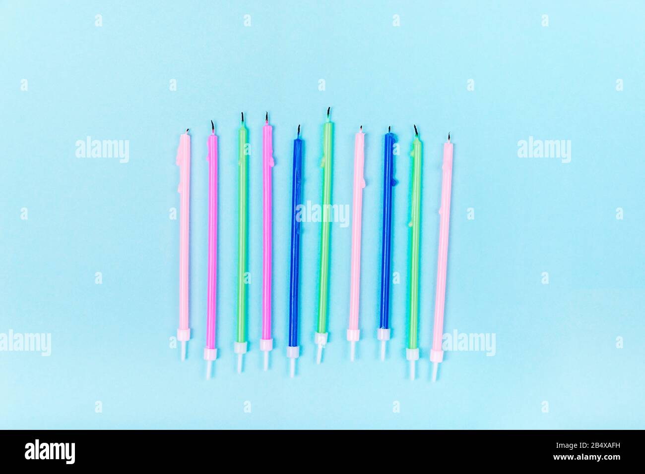 Colorful birthday candles on pastel blue background in a row with copy ...