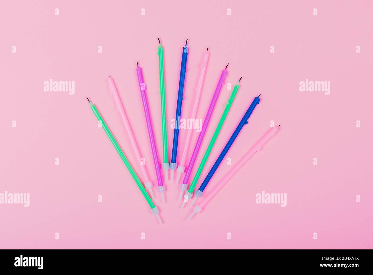 Colorful birthday candles on pastel pink background with copy space ...