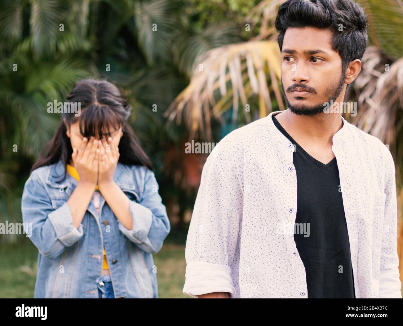 Concept of Teenager couple love breakup - The angry serious boyfriend leaves his sad girlfriend behind. Stock Photo