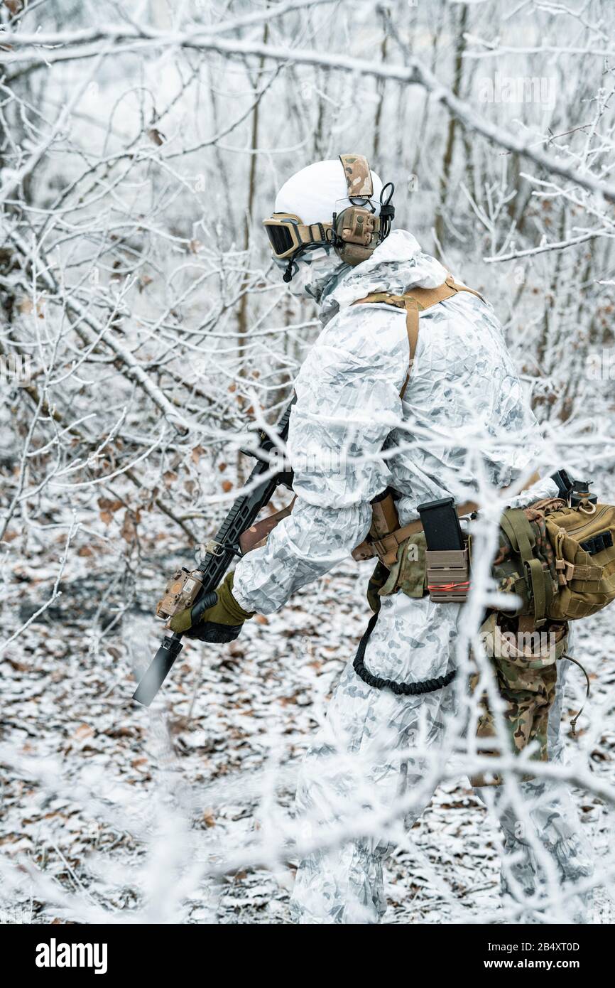 Airsoft man in white camouflage uniform with machinegun. Soldier
