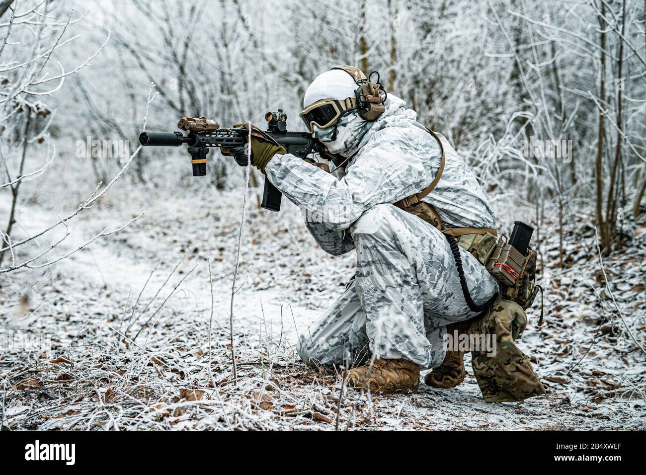 Airsoft man in white camouflage uniform with machinegun. Soldier