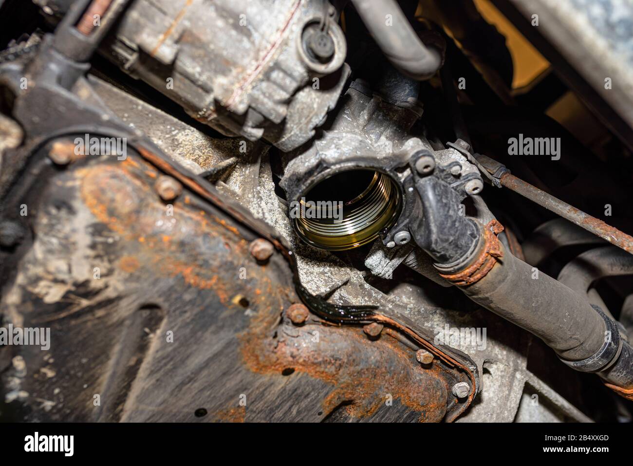 Unscrewed oil filter in the diesel engine from its mounting place at the bottom of the engine next to the oil pan. Stock Photo