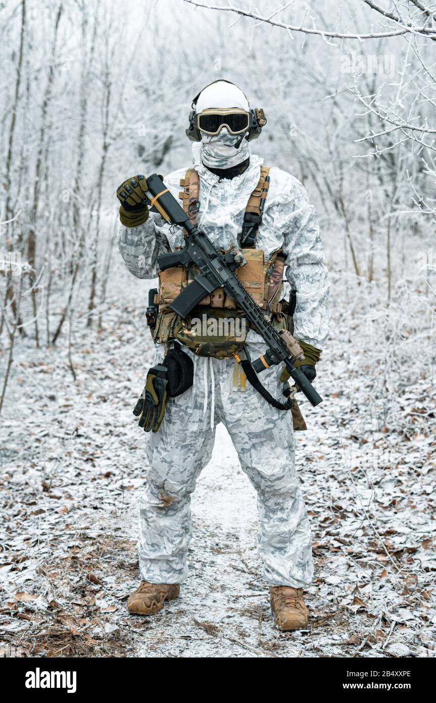 Military man in white camouflage uniform with machinegun. Soldier in the  winter forest territory background. Vertical photo Stock Photo Alamy