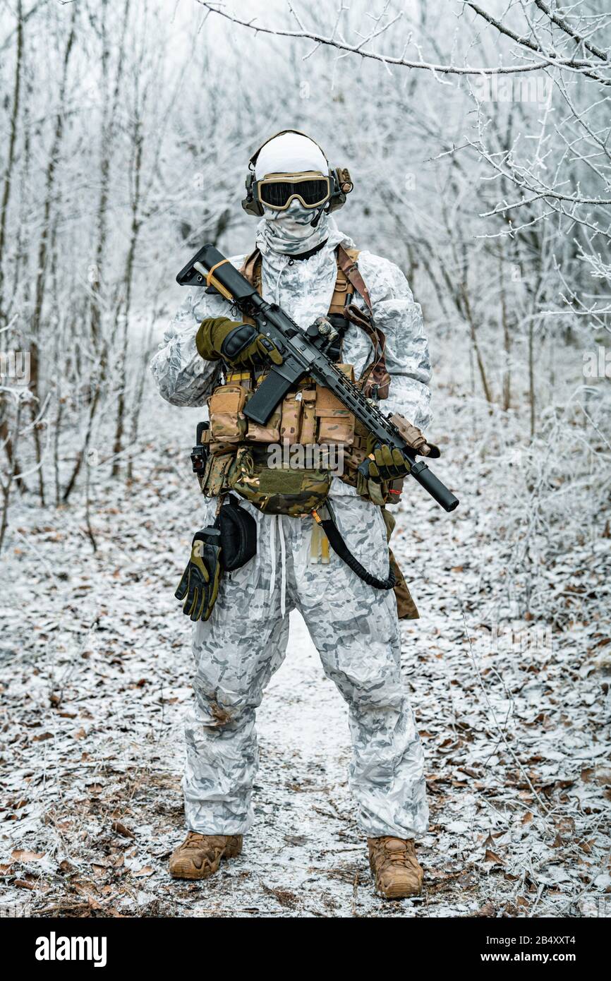 Vervelend Miljard blok Military man in white camouflage uniform with machinegun. Soldier in the  winter forest territory background. Vertical photo Stock Photo - Alamy