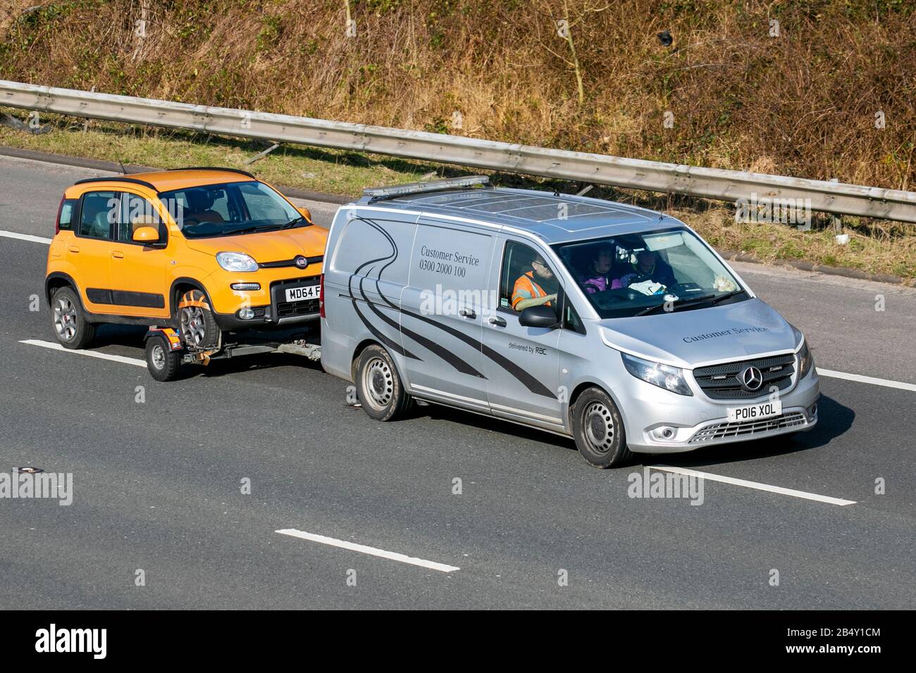 Orange FIAT 500 being towed by RAC  2016 Mercedes-Benz Vito 116 Bluetec; Customer service UK vehicular traffic, transport, modern vehicles, saloon cars, vehicles, vehicle, roads, motors, motoring south-bound on the M6 motorway highway Stock Photo