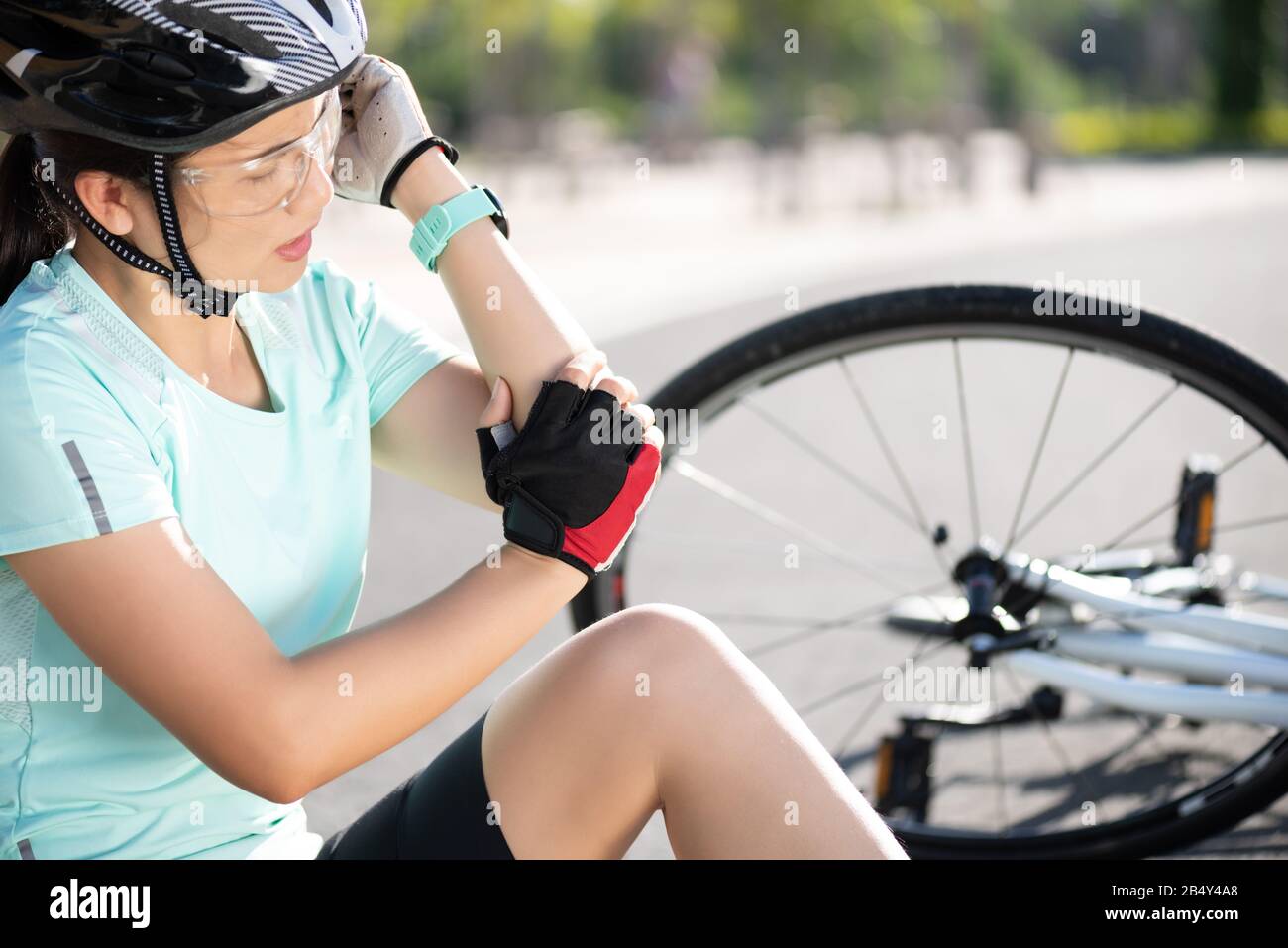 Bike injuries. Woman cyclist fell off road bike while cycling. Bicycle