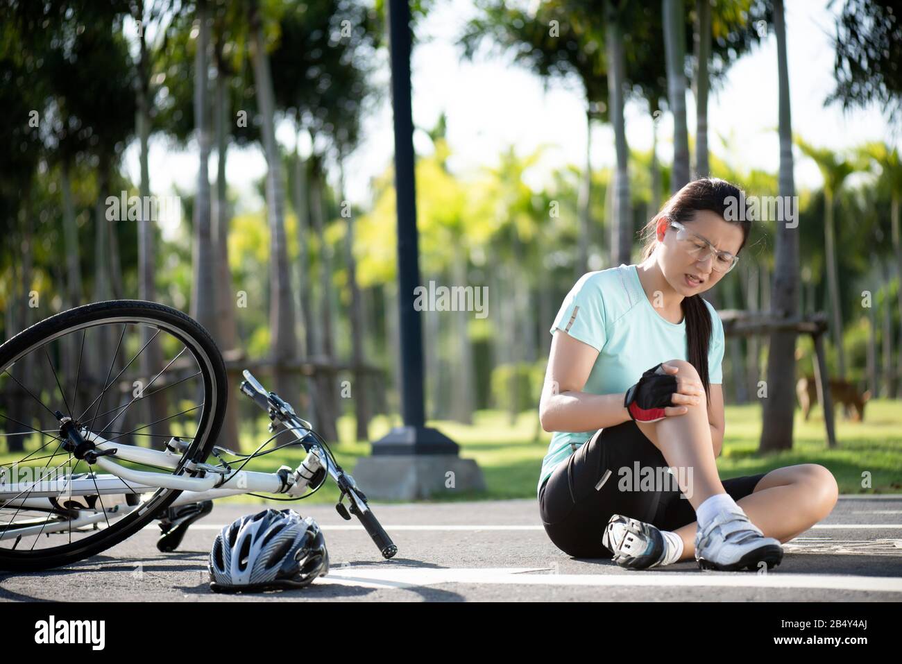 Bike injuries. Young woman cyclist fell fell off road bike while