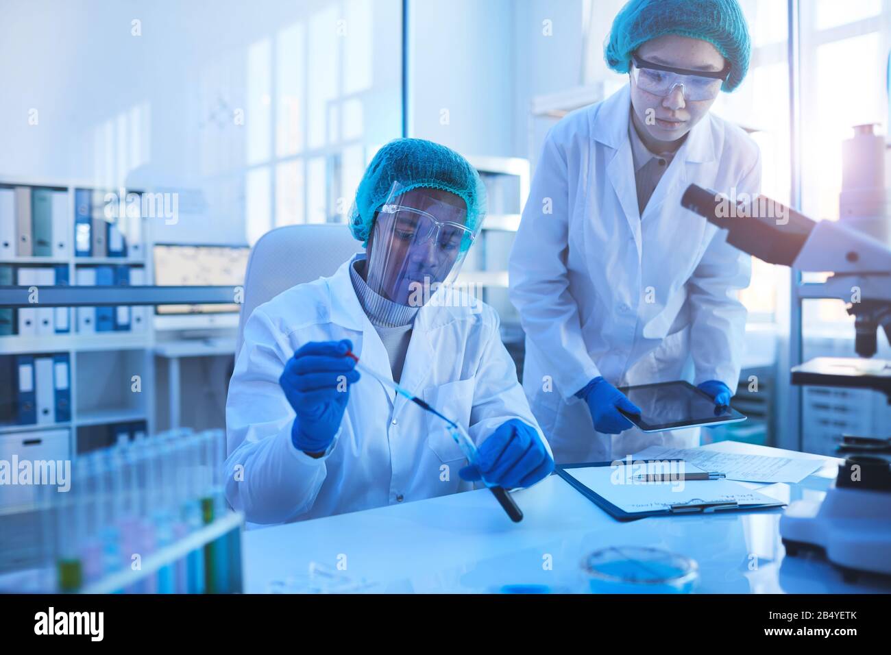 Horizontal portrait of two young scientists wearing protective uniform  coworking in modern medical laboratory, copy space Stock Photo - Alamy