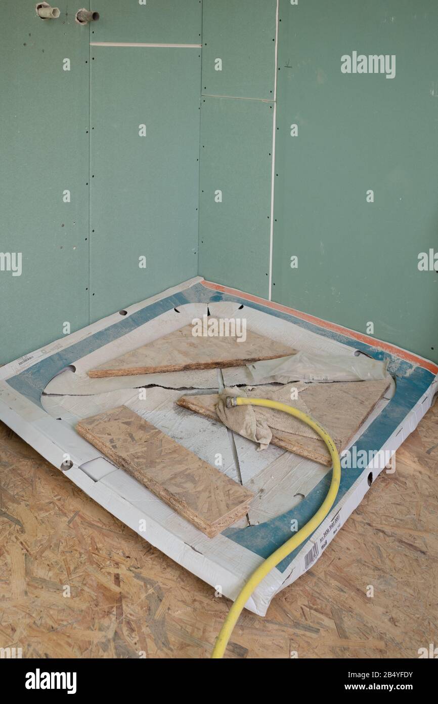 a still packed shower tray lies on the floor of a construction site