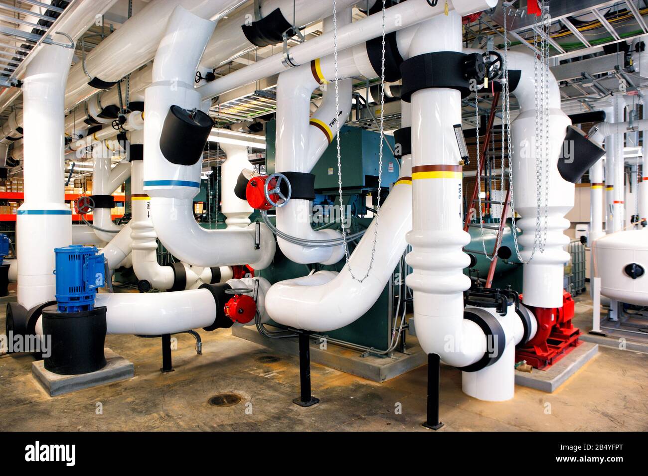 Insulated industrial piping in the heating/cooling plant of a University Stock Photo