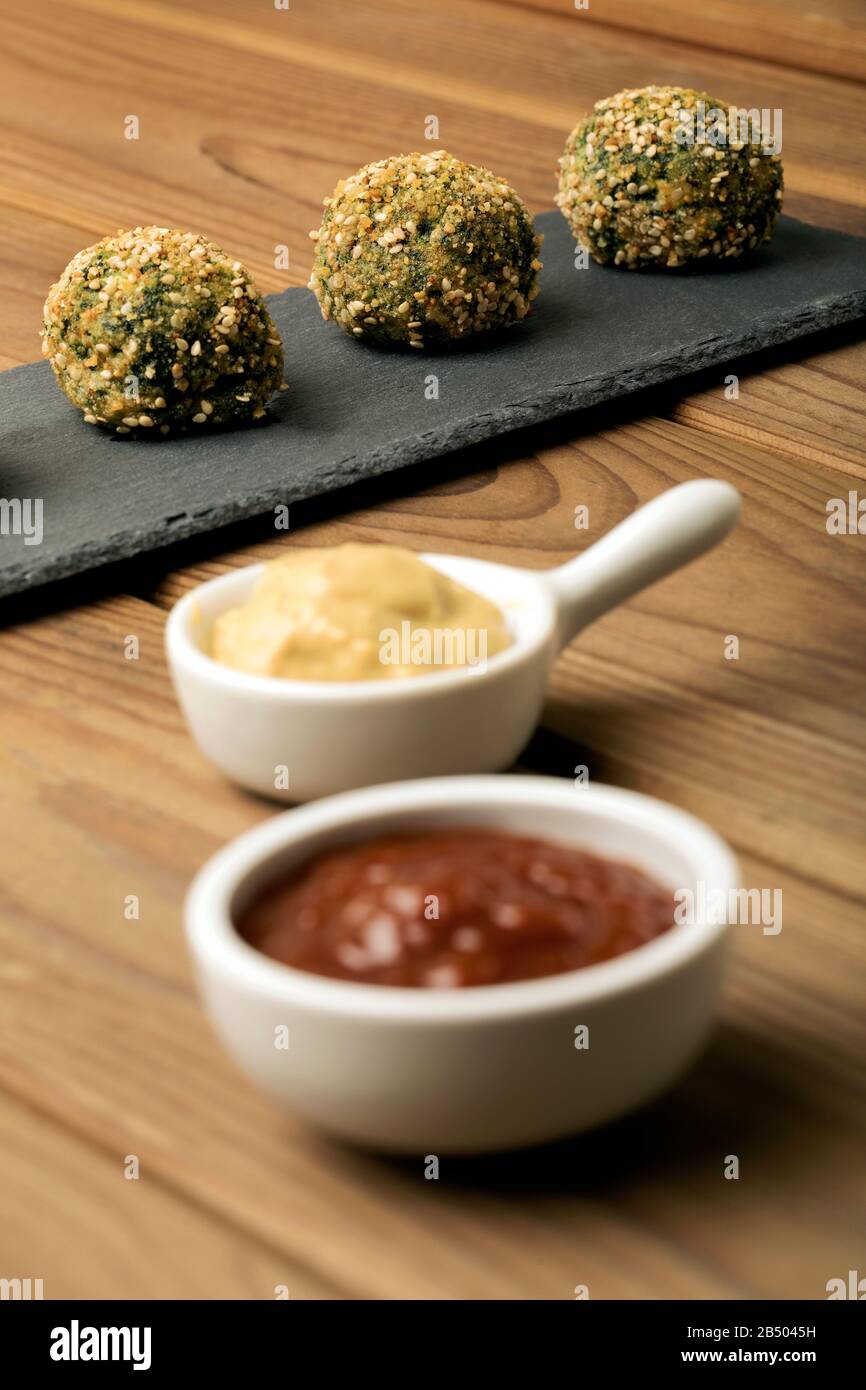 Ketchup and mustard sauces in white bowls and patties of cottage cheese