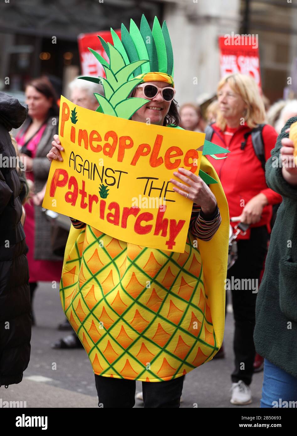 A woman dressed in a pineapple costume during the Million Women Rise march, to demand an end to male violence against women and girls in all its forms, central London. Stock Photo