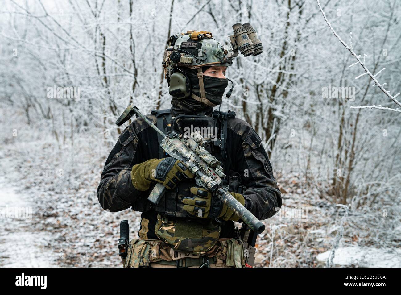 Airsoft man in black camouflage uniform and short machinegun with optical  sight. Soldier in the winter forest. Horizontal photo side view Stock Photo  - Alamy