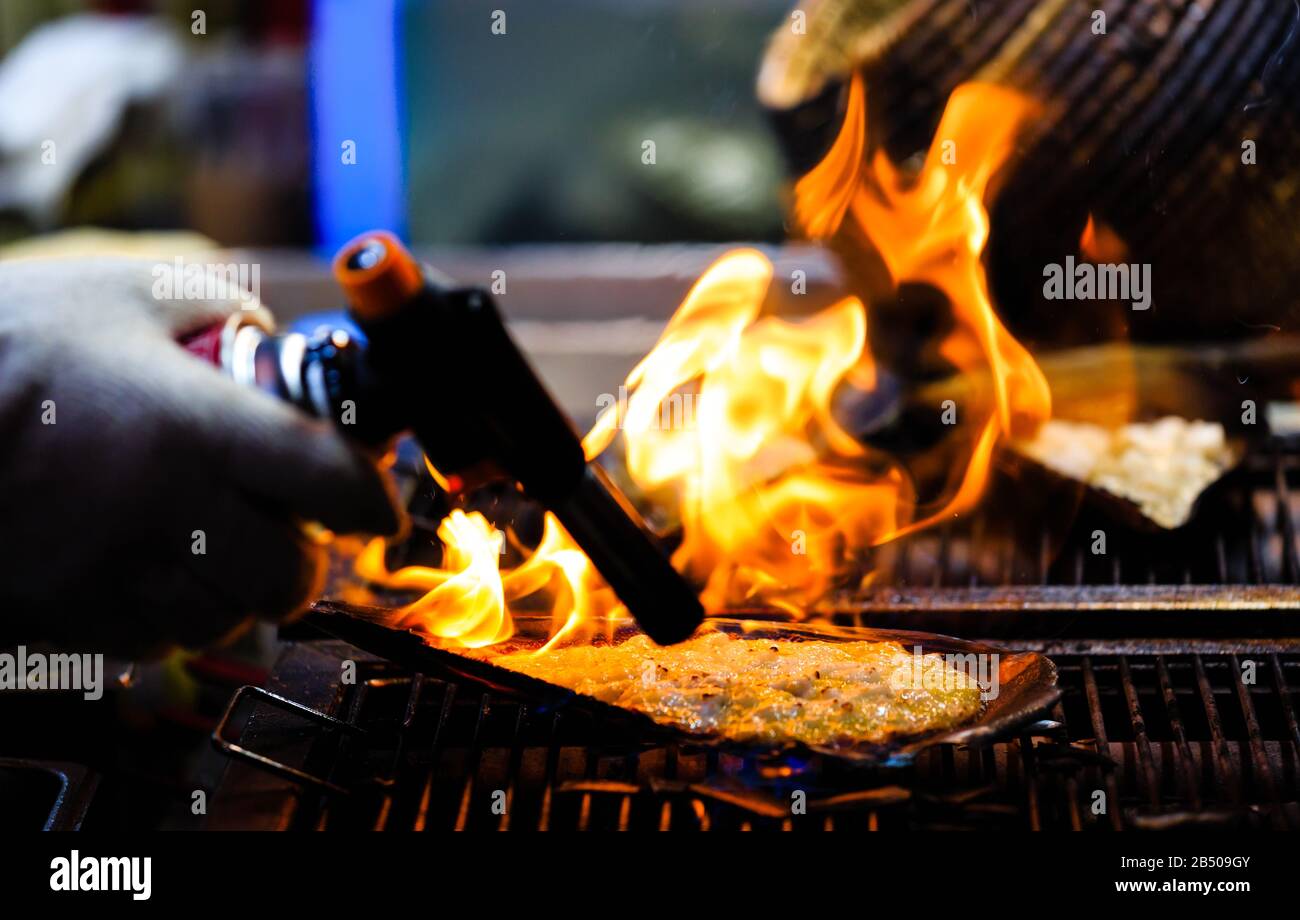 using flame gun to cook meat closeup view Stock Photo Alamy
