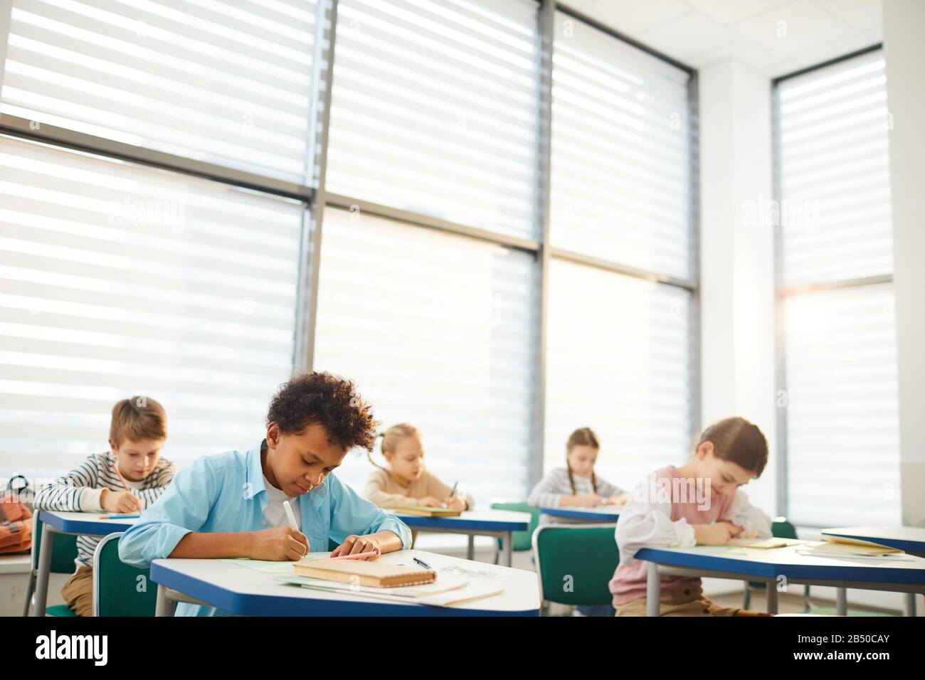 Horizontal Shot Of Young Middle School Students Sitting At Desks