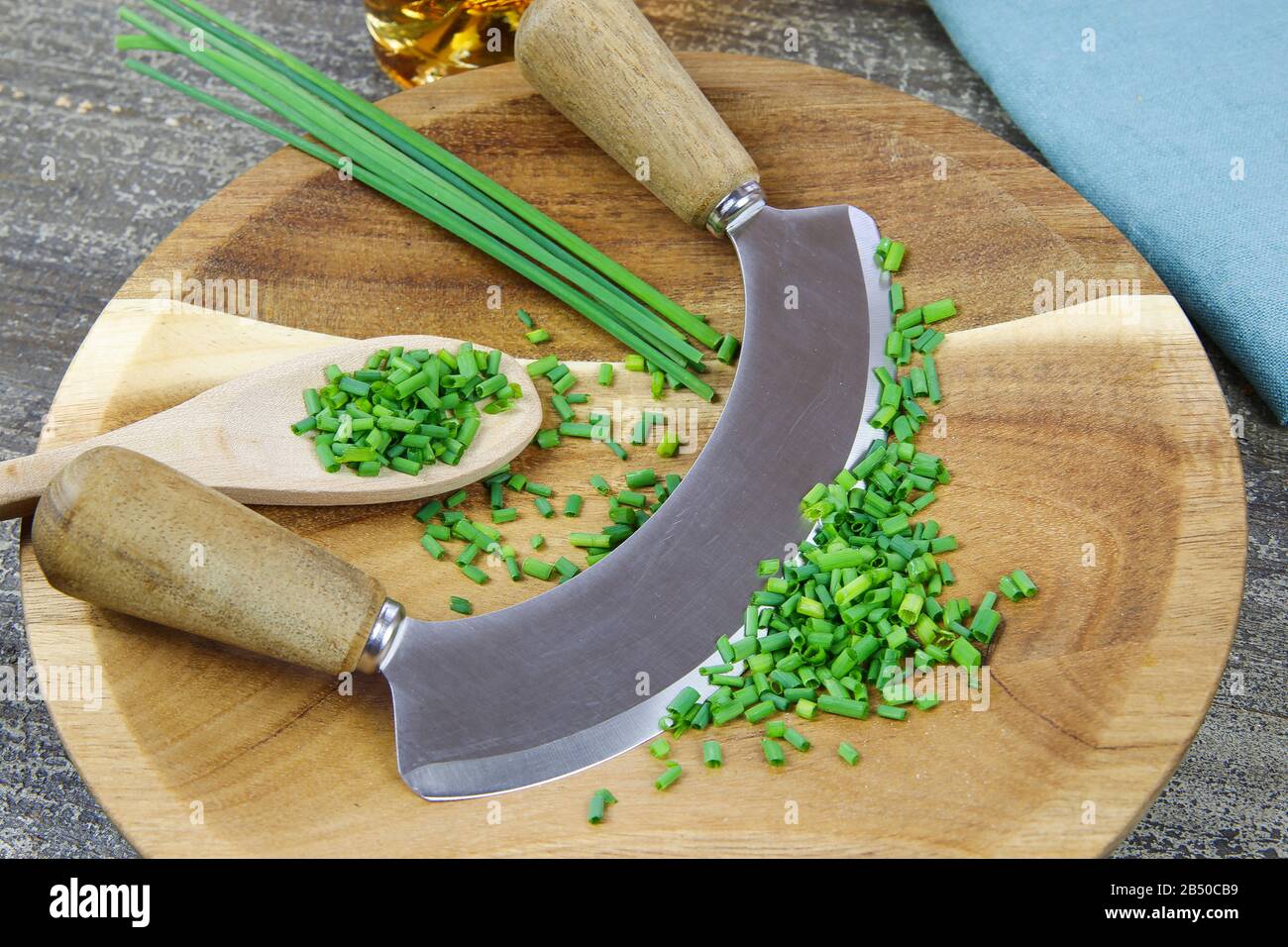 https://c8.alamy.com/comp/2B50CB9/preparation-of-herbs-for-meal-isolated-brown-wood-cutting-board-with-chefs-mincing-knife-chopped-green-chives-and-wooden-spoon-2B50CB9.jpg