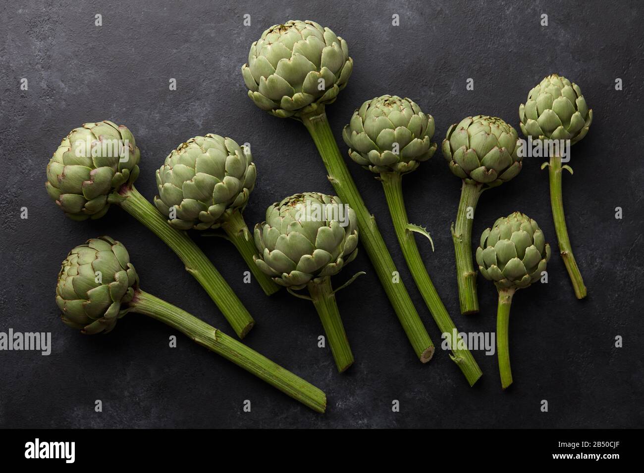 Fresh green artichokes on black background Stock Photo