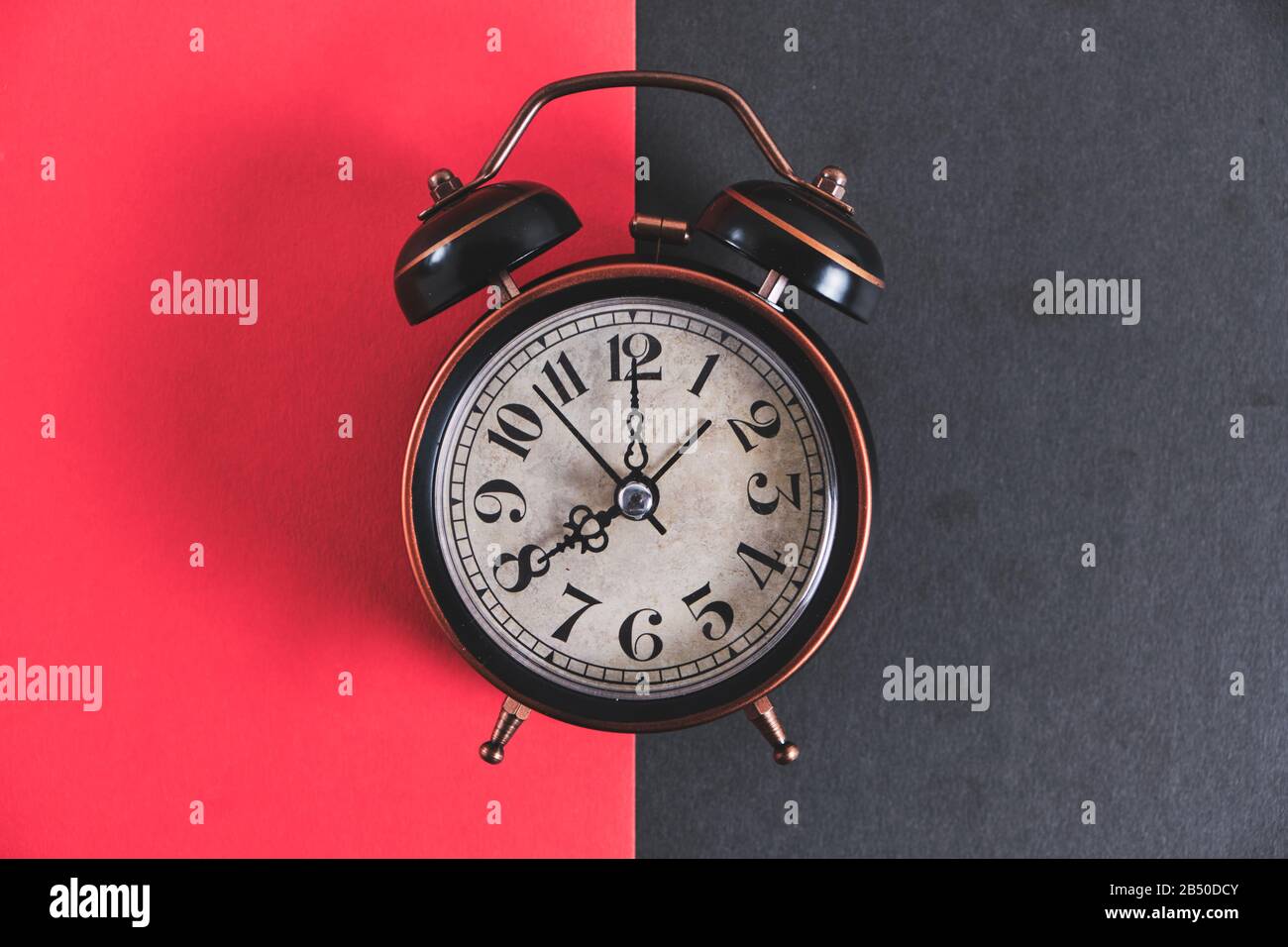 Retro alarm clock on a red and black background Stock Photo - Alamy