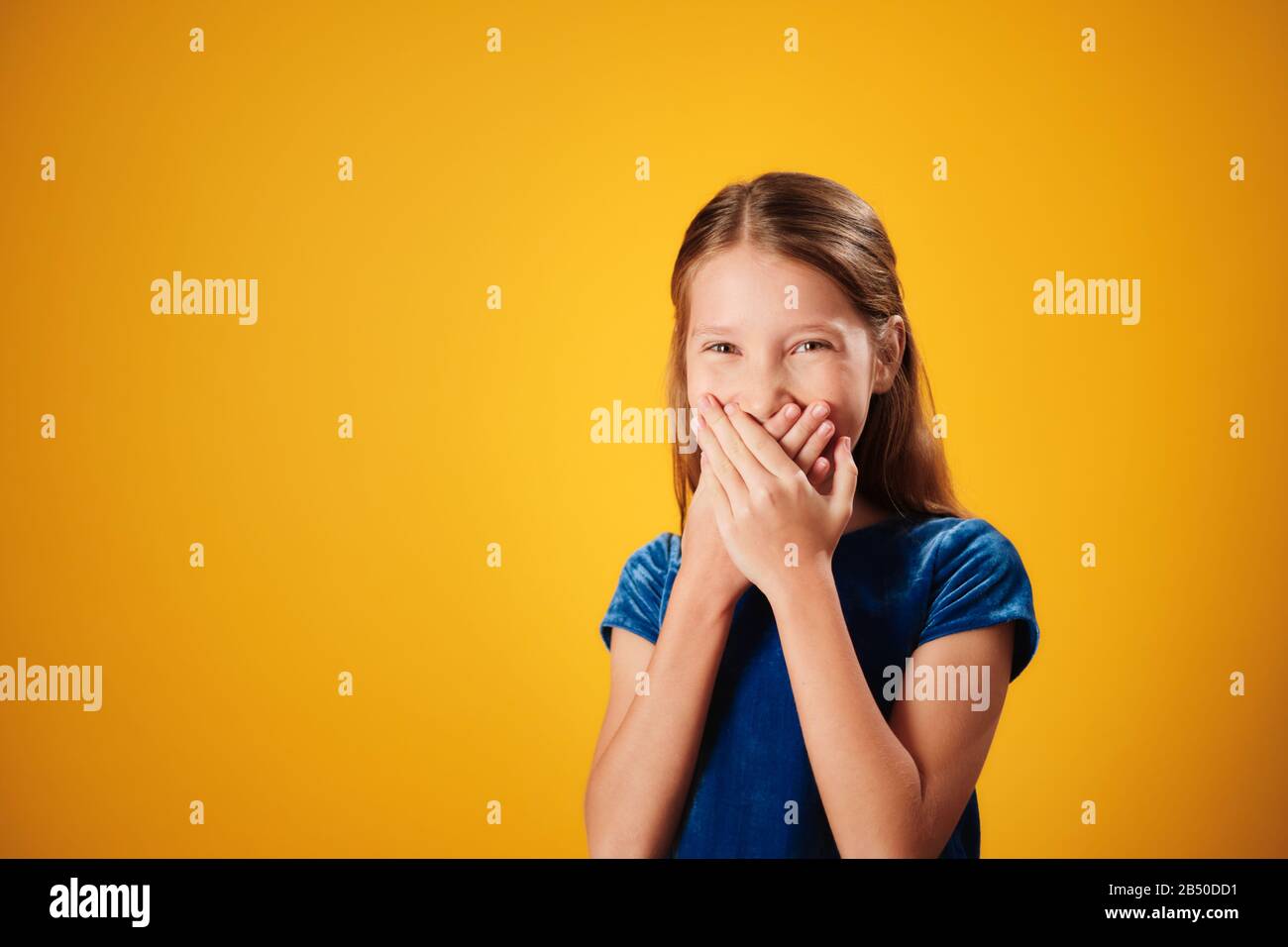 Surprised Little Redhead Girl Smiling And Covering Mouth Stock Photo