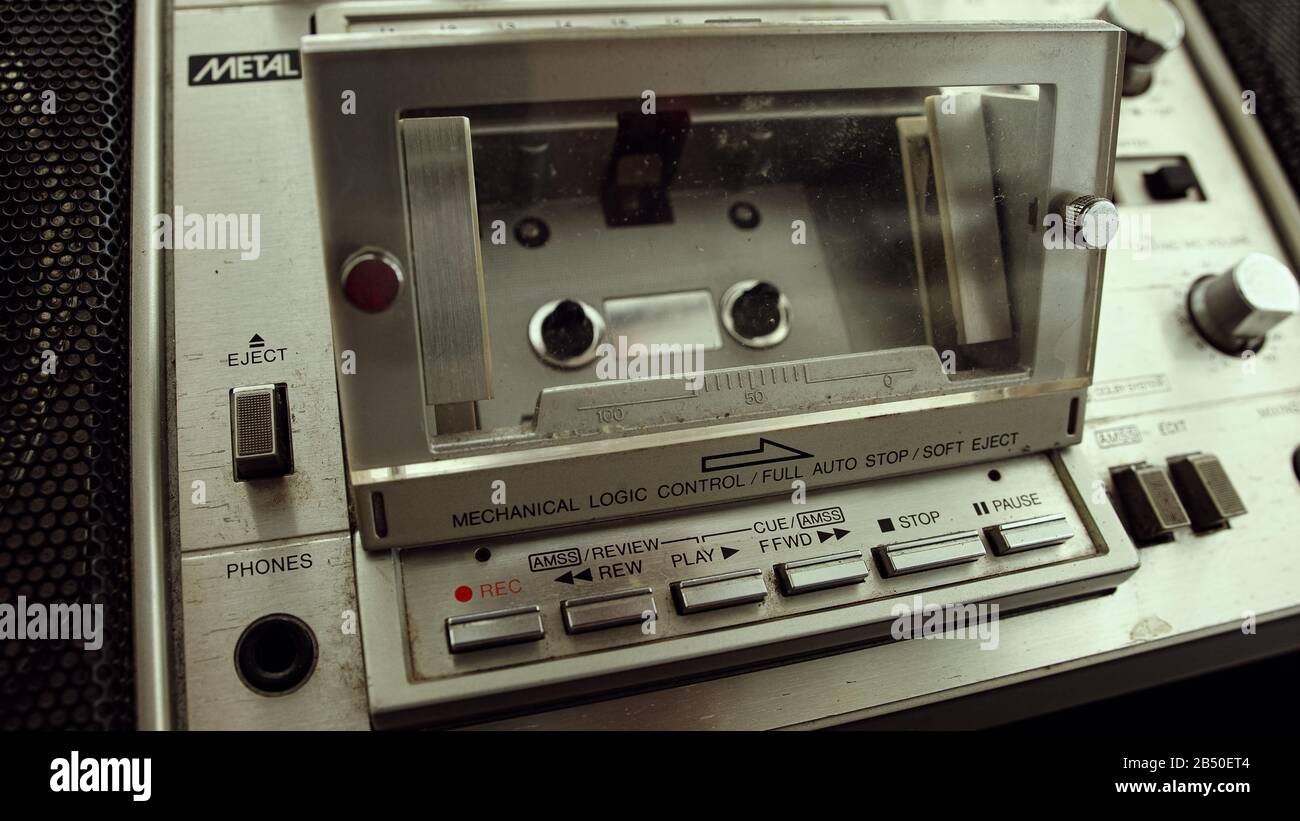 The old cassette player inserts a cassette into the boombox. Retro cassette player concept. Stock Photo