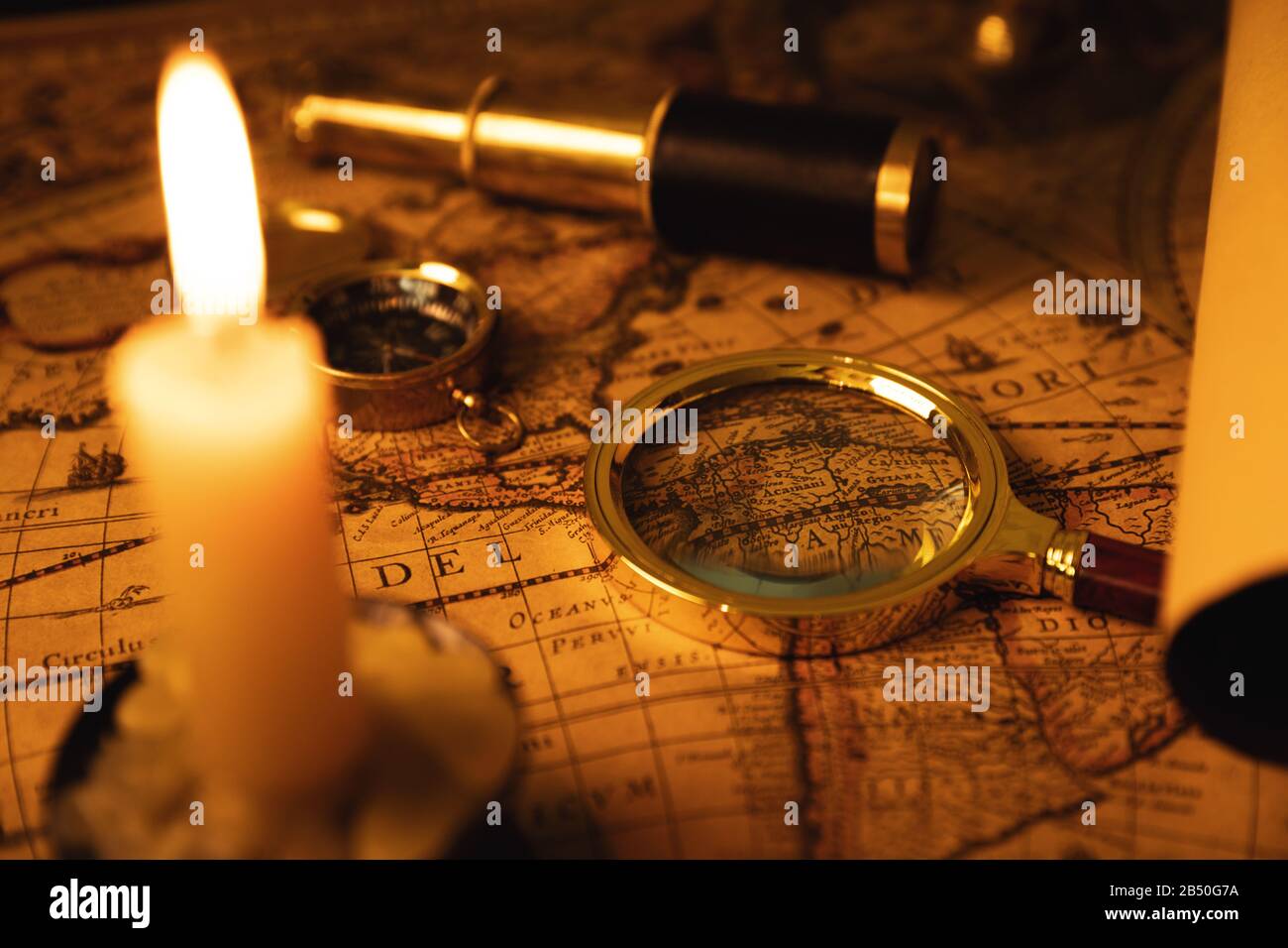 collection of antique objects on old world map in candlelight Stock Photo