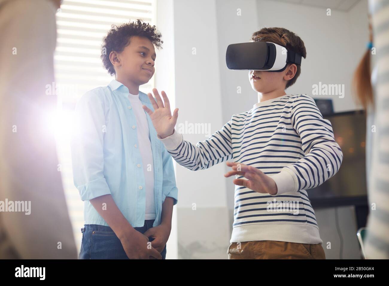 Tenyearold boy wearing VR headset for the first time and his friends