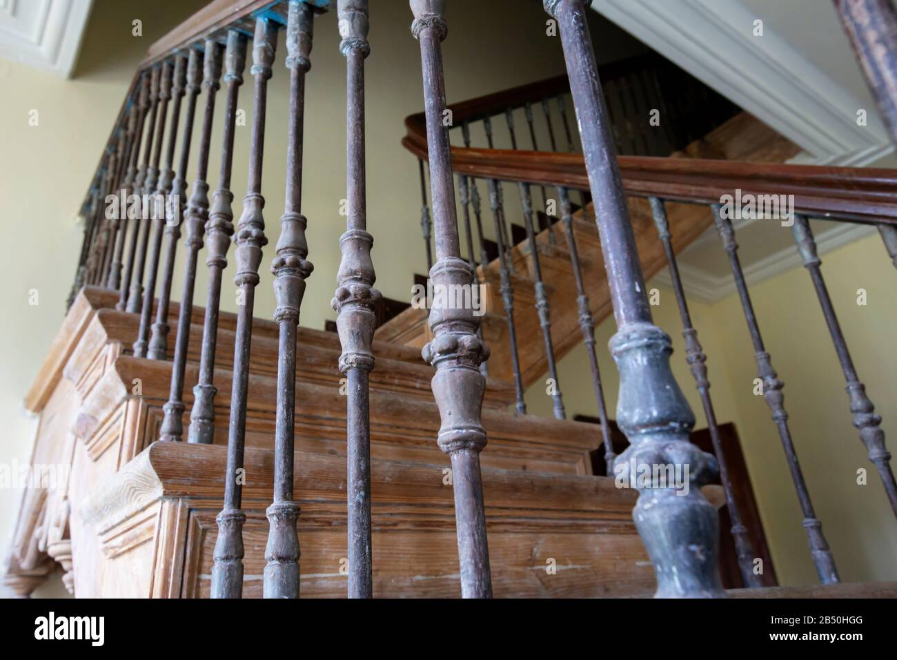 Ancient staircase with iron balusters and wooden railing Stock Photo ...