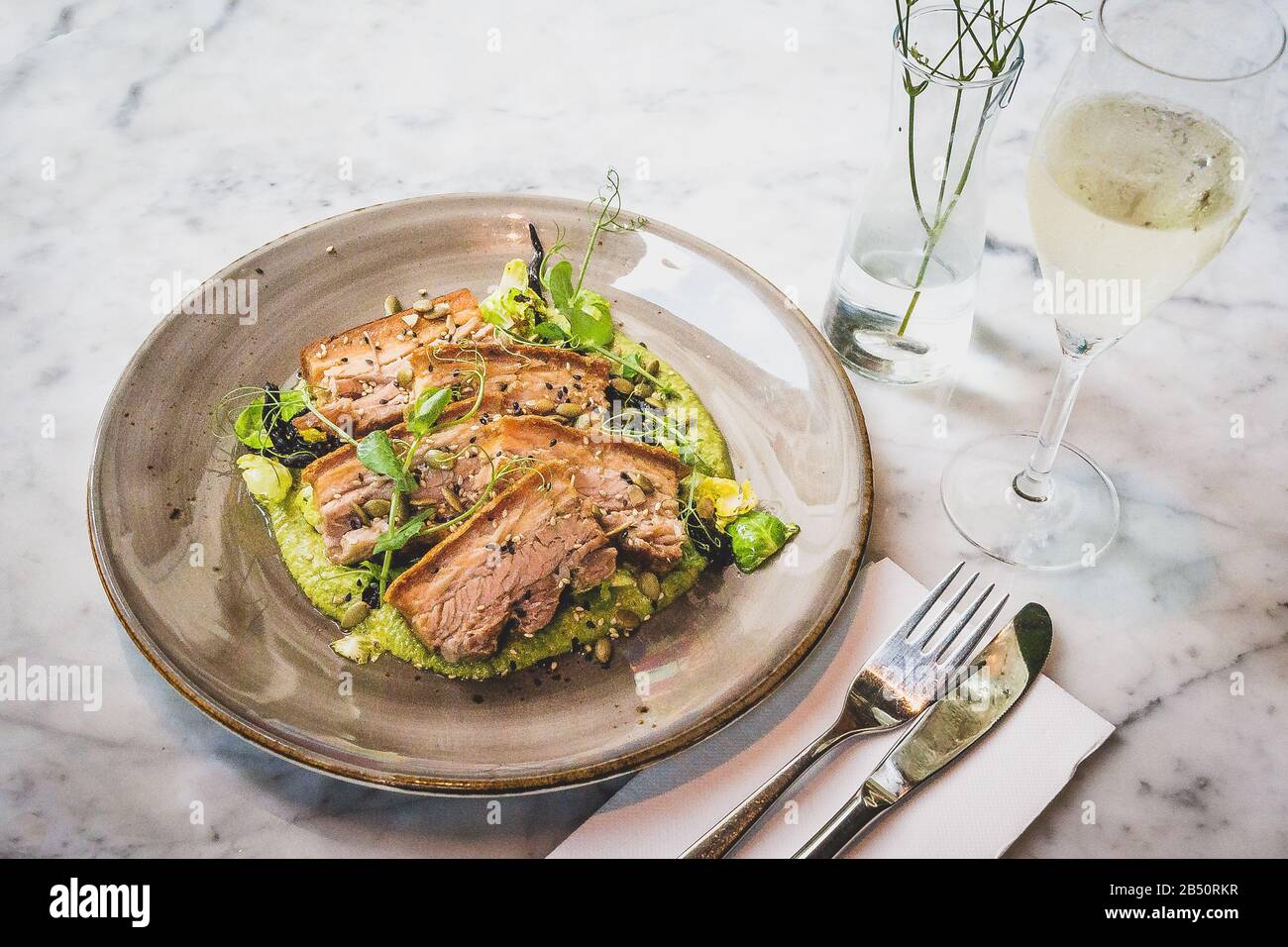 Pork Belly In Pipian Verde 14 hour slow cooked pork belly with crunchy skin, pumpkin seeds and green tomatillos salsa. Stock Photo