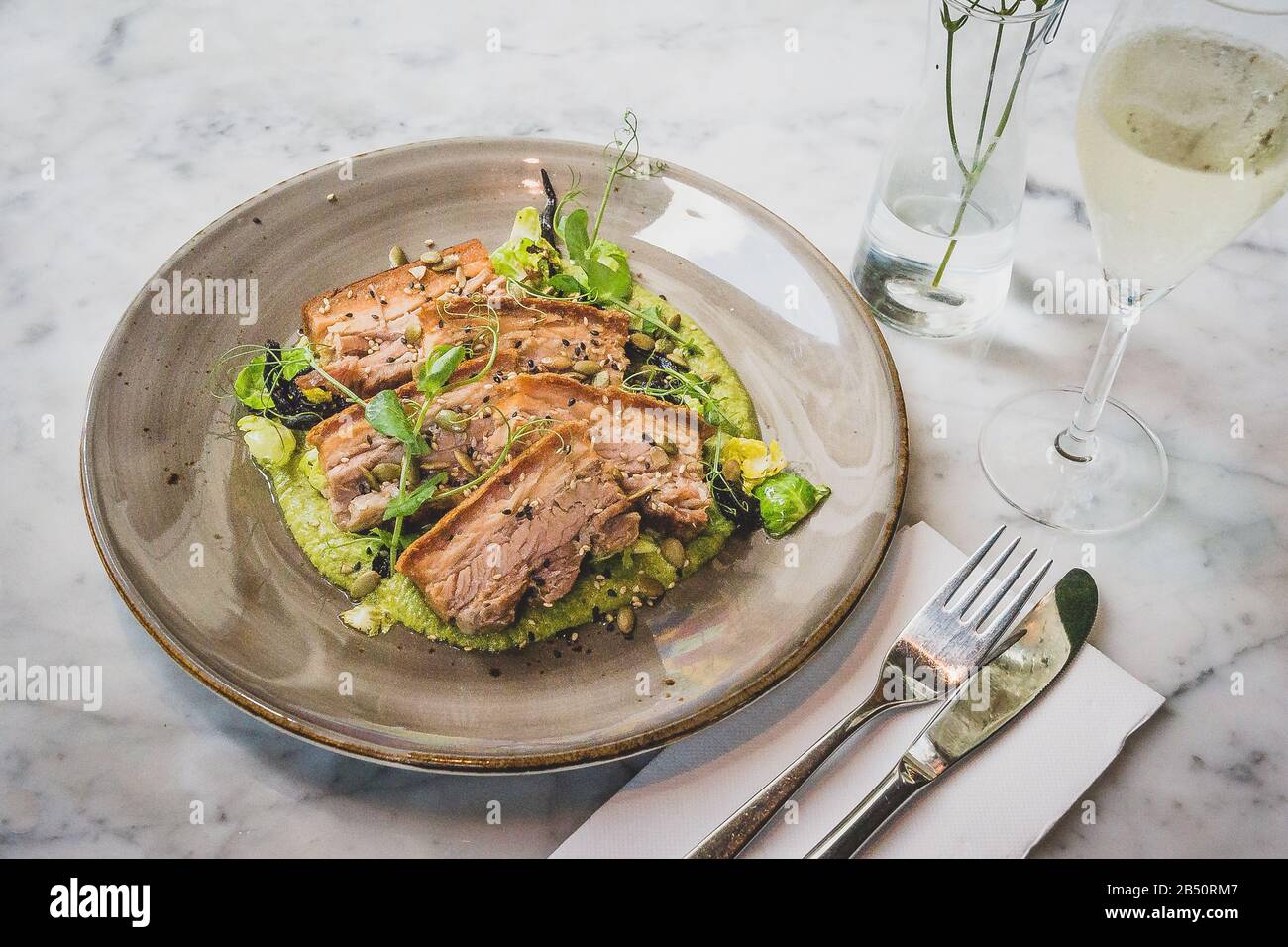 Pork Belly In Pipian Verde 14 hour slow cooked pork belly with crunchy skin, pumpkin seeds and green tomatillos salsa. Stock Photo