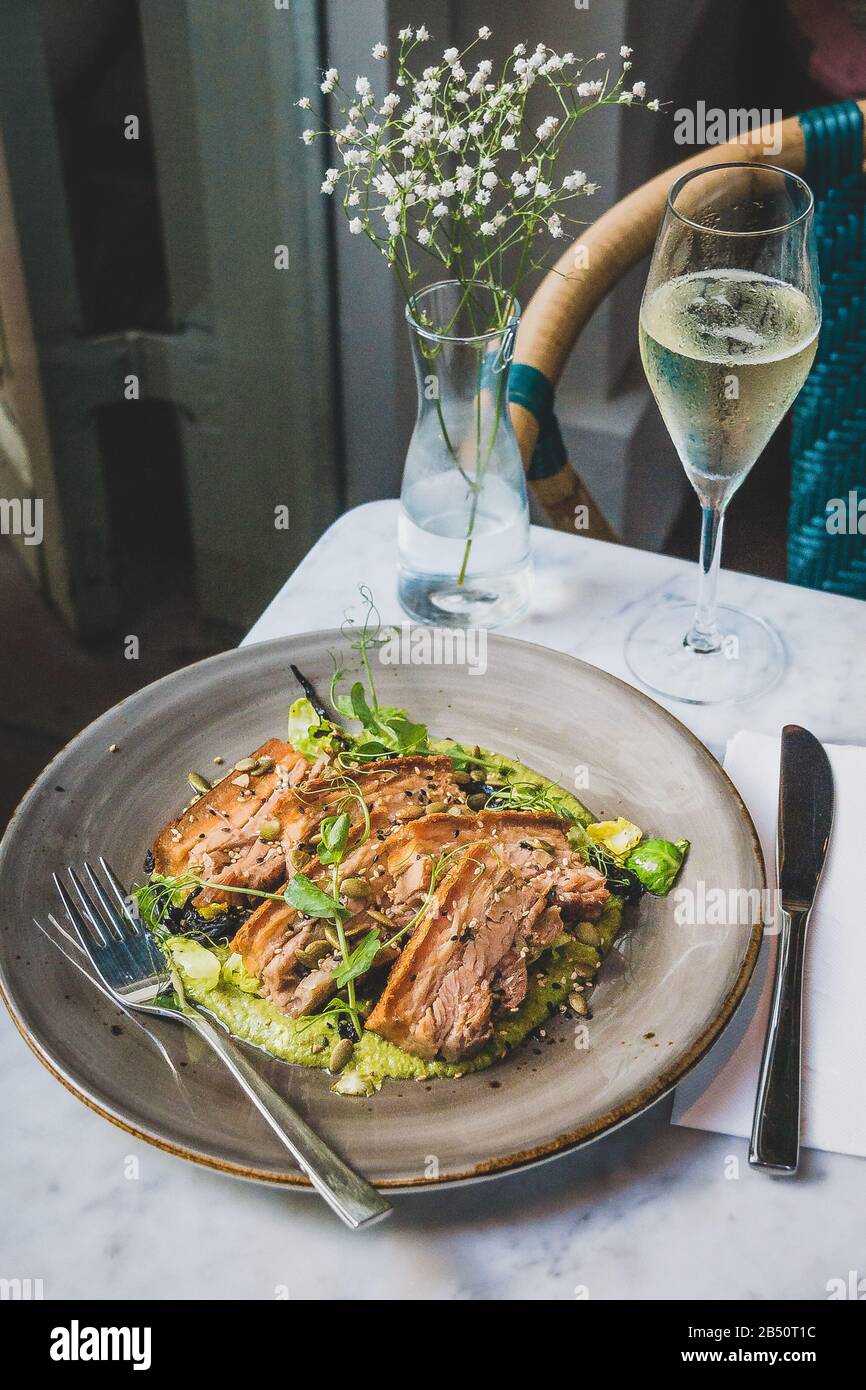 Pork Belly In Pipian Verde 14 hour slow cooked pork belly with crunchy skin, pumpkin seeds and green tomatillos salsa. Stock Photo