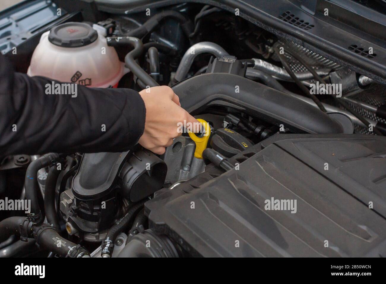 Closeup woman hands repairing a car. Women makes service control of a vehicle. Stock Photo