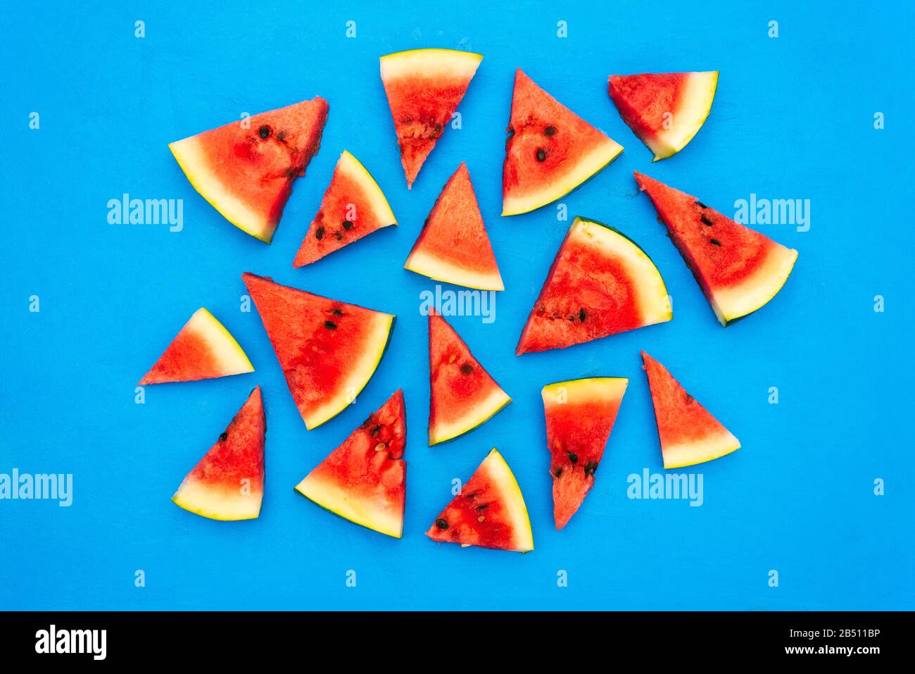 Watermelon slices on a blue canvas. Fresh juicy slices of watermelon. Sweet summer dessert on a bright background Stock Photo