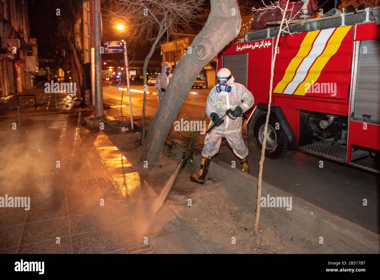 Disinfection of public places and thoroughfares in Shiraz, Lotfali-Khan-Zand St. is underway with the aim of preventing and combating outbreak of Coronavirus(COVID-19). For this purpose, experts of health ministry have cooperated with the provincial fire department and disinfect the city in late hours of the night using machinery and mobile pumps. Iran, Fars province, Shiraz city. Stock Photo