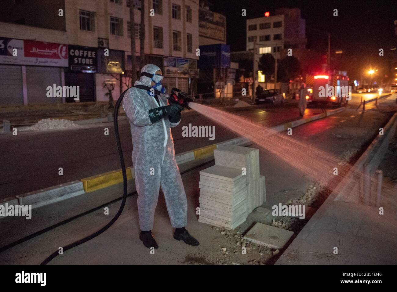 Disinfection of public places and thoroughfares in Shiraz, Afif-Abaad St. is underway with the aim of preventing and combating outbreak of Coronavirus(COVID-19). For this purpose, experts of health ministry have cooperated with the provincial fire department and disinfect the city in late hours of the night using machinery and mobile pumps. Iran, Fars province, Shiraz city. Stock Photo