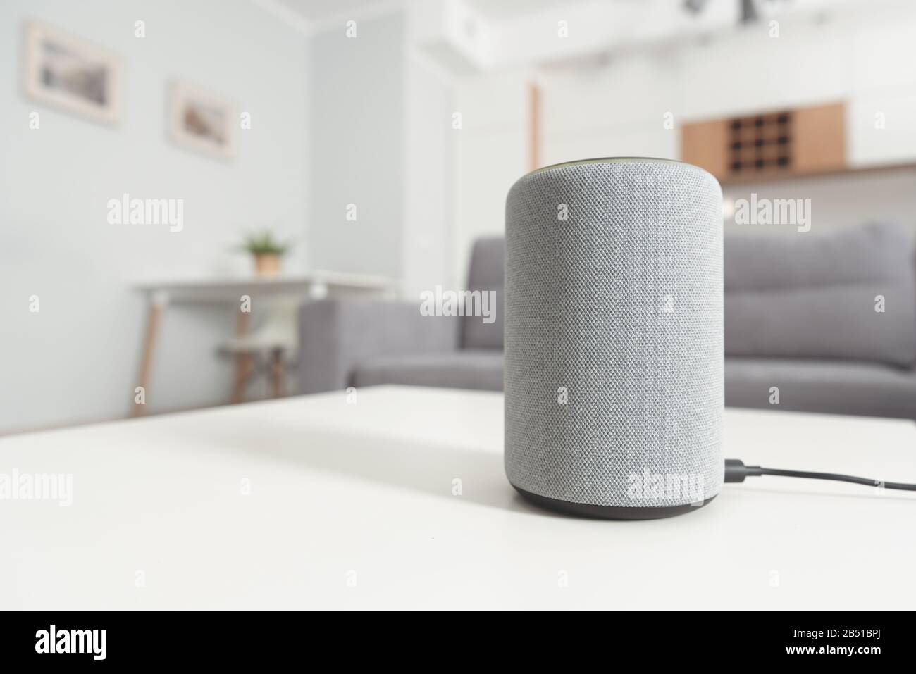 Smart speaker device in living room. Intelligent assistant in smart home system. Stock Photo