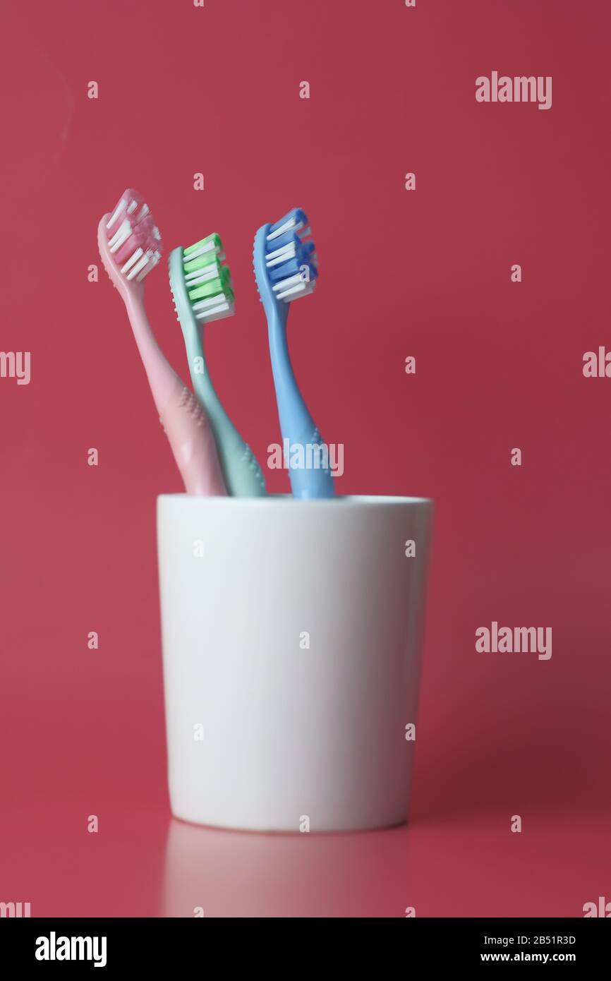 toothbrush in a glass on a red background Stock Photo