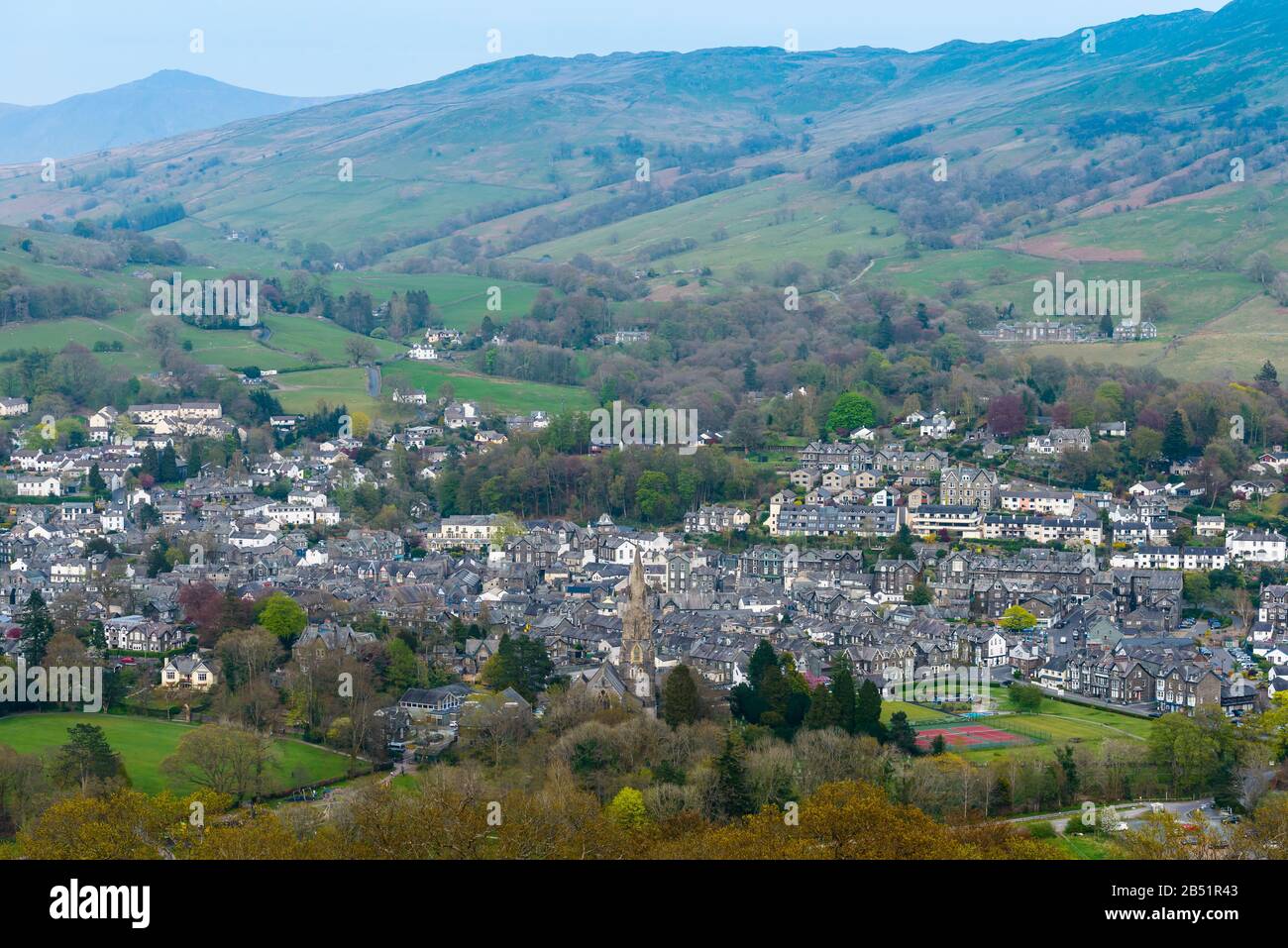 The town of Ambleside and its St Mary's Church with a stone spire built in the 1850s seen from Loughrigg Fell, Lake District, Cumbria, England. Stock Photo