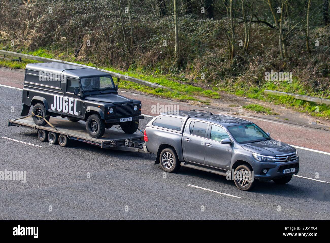 JUBEL Land Rover on trailer tow; UK vehicular traffic, transport, modern vehicles, saloon cars, vehicles, vehicle, roads, motors, motoring south-bound on the M6 motorway highway Stock Photo