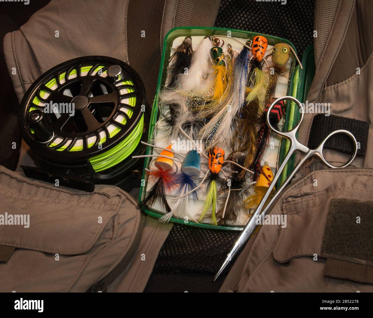Still life composition of fly fishing equipment including a vest, reel