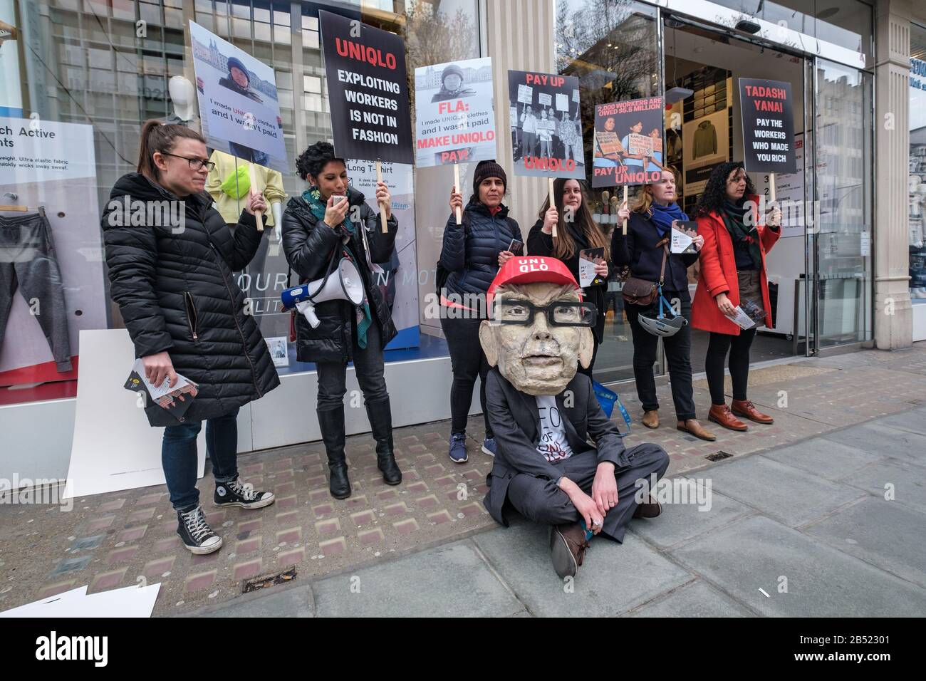 London, UK. 7th Mar, 2020. A protest outside the Uniqlo flagship store in  Oxford St features a man wearing a giant head of CEO Tadashi Yanai, the  31st richest person in the